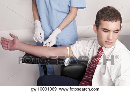 Doctor taking blood sample of a man View Large Photo Image Stock Photo - Doctor taking blood sample of a man. Fotosearch