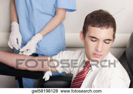 Doctor taking blood sample of a man View Large Photo Image Stock Photo - Doctor taking blood sample of a man. Fotosearch