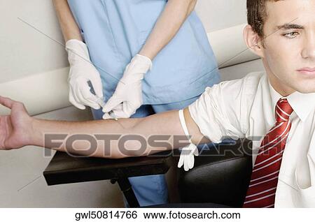 Doctor taking blood sample of a man View Large Photo Image Stock Photograph - Doctor taking blood sample of a man. Fotosearch