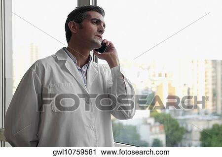 Doctor talking on a mobile phone View Large Photo Image Stock Image - Doctor talking on a mobile phone. Fotosearch