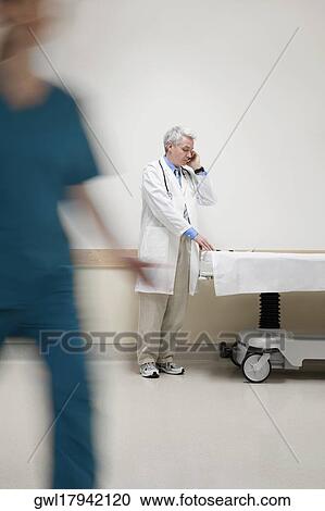 Doctor talking on a mobile phone View Large Photo Image Stock Image - Doctor talking on a mobile phone. Fotosearch