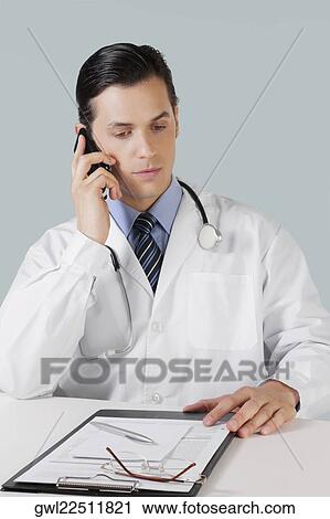 Doctor talking on a mobile phone View Large Photo Image Stock Image - Doctor talking on a mobile phone. Fotosearch