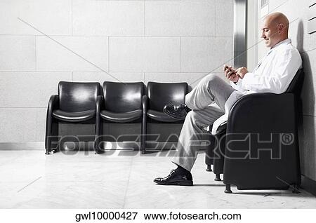 Stock Photo - Doctor text messaging on a mobile phone. Fotosearch