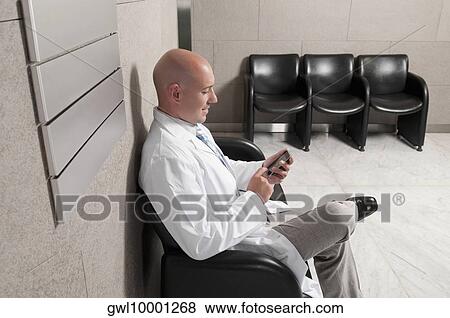 Doctor text messaging on a mobile phone View Large Photo Image Stock Photo - Doctor text messaging on a mobile phone. Fotosearch