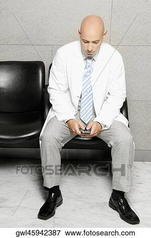 Doctor text messaging on a mobile phone View Large Photo Image Stock Photo - Doctor text messaging on a mobile phone. Fotosearch