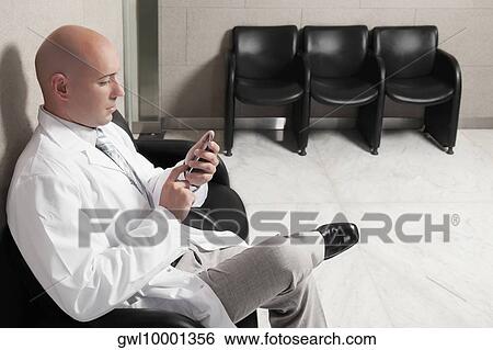Doctor text messaging on a mobile phone View Large Photo Image Stock Photograph - Doctor text messaging on a mobile phone. Fotosearch