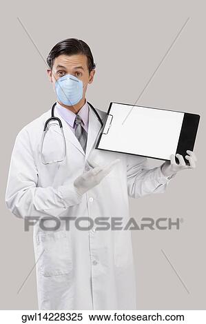 Doctor wearing a flu mask and showing a clip board View Large Photo Image Stock Photography - Doctor wearing a flu mask and showing a clip board. Fotosearch
