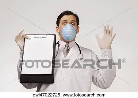 Doctor wearing a flu mask and showing a clipboard View Large Photo Image Stock Photography - Doctor wearing a flu mask and showing a clipboard. Fotosearch