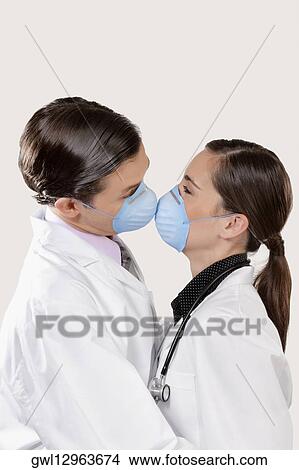 Picture - Doctor wearing swine flu masks and romancing. Fotosearch