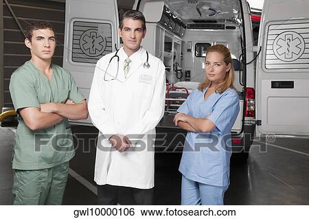 Doctor with co-workers standing in front of an ambulance View Large Photo Image Stock Photograph - Doctor with co-workers standing in front of an ambulance. Fotosearch
