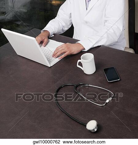 Doctor working on a laptop View Large Photo Image Stock Image - Doctor working on a laptop. Fotosearch