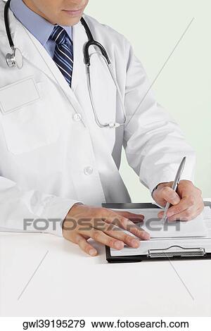 Doctor writing on a clipboard View Large Photo Image Stock Photo - Doctor writing on a clipboard. Fotosearch