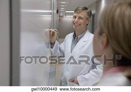 Doctor writing on a whiteboard in a hospital View Large Photo Image Stock Photo - Doctor writing on a whiteboard in a hospital. Fotosearch