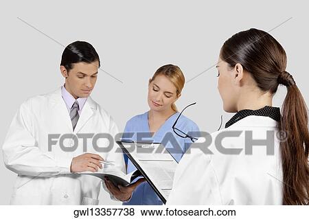 Doctors and a nurse discussing about medical record View Large Photo Image Stock Photo - Doctors and a nurse discussing about medical record. Fotosearch