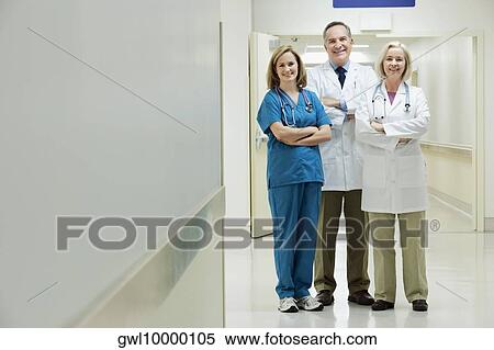 Doctors and a nurse standing in a hospital corridor View Large Photo Image Stock Photography - Doctors and a nurse standing in a hospital corridor. Fotosearch