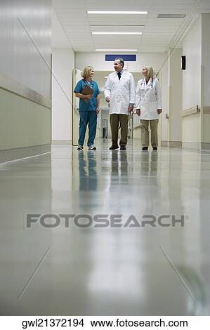 Picture - Doctors and a nurse walking in a hospital corridor. Fotosearch