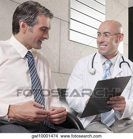 Doctors discussing a medical report View Large Photo Image Picture - Doctors discussing a medical report. Fotosearch