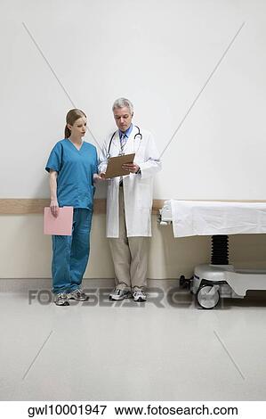 Doctors discussing a medical report with a nurse View Large Photo Image Stock Photo - Doctors discussing a medical report with a nurse. Fotosearch