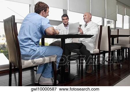 Doctors discussing in a cafeteria View Large Photo Image Stock Photo - Doctors discussing in a cafeteria. Fotosearch