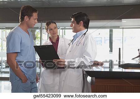 Doctors discussing with a male nurse View Large Photo Image Stock Photo - Doctors discussing with a male nurse. Fotosearch
