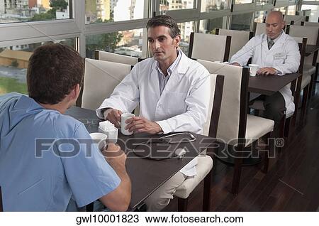 Doctors during coffee break a cafeteria View Large Photo Image Stock Image - Doctors during coffee break a cafeteria. Fotosearch