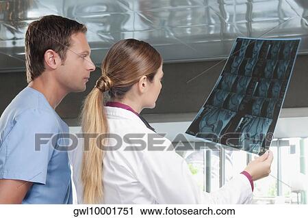Doctors examining an X-Ray report View Large Photo Image Stock Image - Doctors examining an X-Ray report. Fotosearch