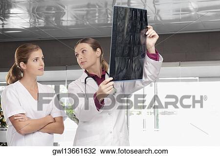 Doctors examining an X-Ray report View Large Photo Image Stock Image - Doctors examining an X-Ray report. Fotosearch