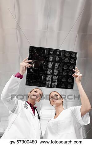 Doctors examining an X-Ray report View Large Photo Image Stock Image - Doctors examining an X-Ray report. Fotosearch