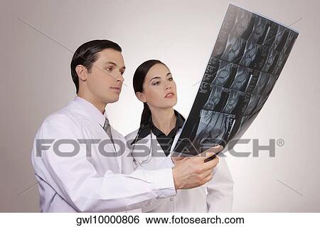 Doctors examining an x-ray report View Large Photo Image Stock Photograph - Doctors examining an x-ray report. Fotosearch