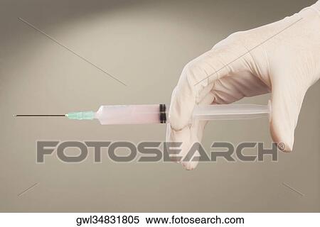 Doctor's hand holding an injection View Large Photo Image Stock Photography - Doctor's hand holding an injection. Fotosearch