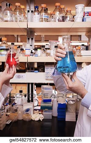 Doctors holding conical flasks in a laboratory View Large Photo Image Stock Image - Doctors holding conical flasks in a laboratory. Fotosearch