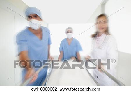 Doctors pushing a patient on a hospital Gurney in a hospital corridor View Large Photo Image Stock Image - Doctors pushing a patient on a hospital Gurney in a hospital corridor. Fotosearch