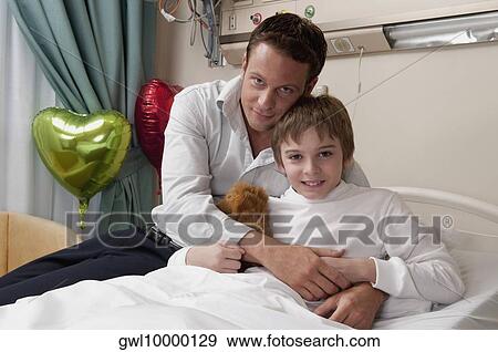 Father with his son in a hospital View Large Photo Image Stock Photo - Father with his son in a hospital. Fotosearch