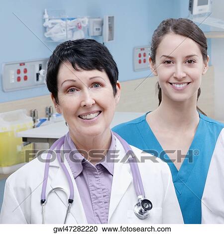 Stock Image - Female doctor and a nurse smiling. Fotosearch