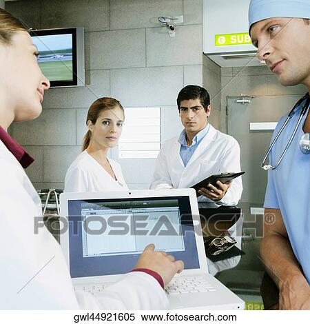 Female doctor and a surgeon discussing a medical report on a laptop View Large Photo Image Stock Photography - Female doctor and a surgeon discussing a medical report on a laptop. Fotosearch