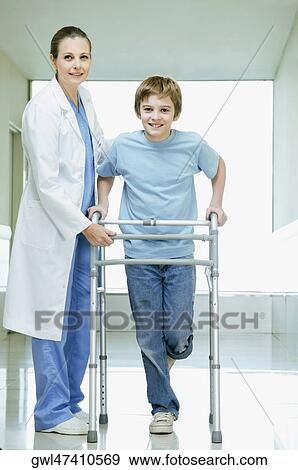 Female doctor assisting a boy with a walker View Large Photo Image Stock Photo - Female doctor assisting a boy with a walker. Fotosearch