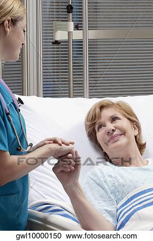 Stock Image - Female doctor discussing with a patient. Fotosearch