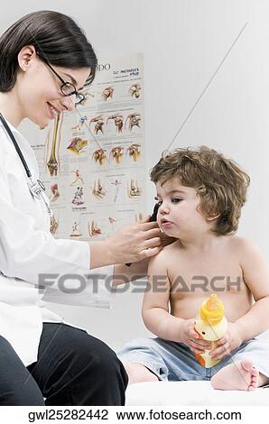 Female doctor examining a baby boy's ear with an otoscope View Large Photo Image Stock Image - Female doctor examining a baby boy's ear with an otoscope. Fotosearch