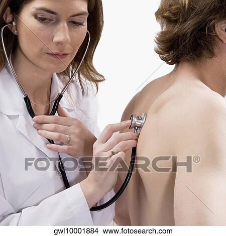 Female doctor examining a man with a stethoscope View Large Photo Image Picture - Female doctor examining a man with a stethoscope. Fotosearch