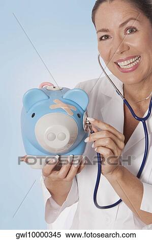 Female doctor examining a piggy bank with a stethoscope View Large Photo Image Stock Photography - Female doctor examining a piggy bank with a stethoscope. Fotosearch