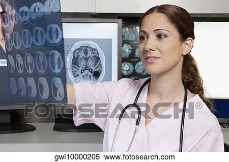 Female doctor examining an x-ray report View Large Photo Image Stock Photography - Female doctor examining an x-ray report. Fotosearch