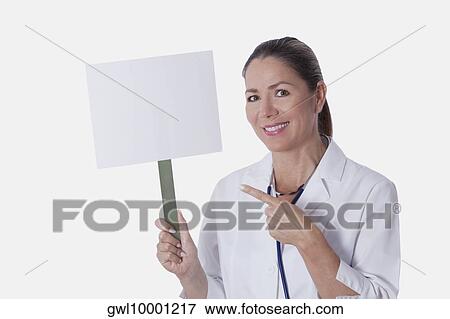 Female doctor holding a blank placard View Large Photo Image Stock Photo - Female doctor holding a blank placard. Fotosearch