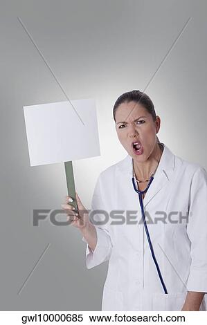 Female doctor holding a blank placard View Large Photo Image Stock Photography - Female doctor holding a blank placard. Fotosearch