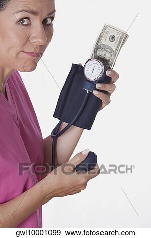 Female doctor holding a blood pressure gauge with currency notes View Large Photo Image Stock Photo - Female doctor holding a blood pressure gauge with currency notes. Fotosearch