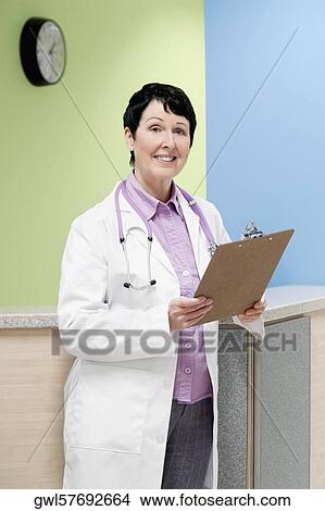 Female doctor holding a clipboard View Large Photo Image Picture - Female doctor holding a clipboard. Fotosearch
