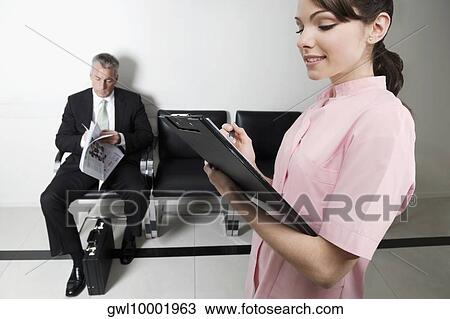 Stock Image - Female doctor holding a clipboard. Fotosearch