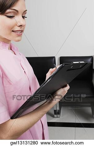 Female doctor holding a clipboard View Large Photo Image Stock Image - Female doctor holding a clipboard. Fotosearch