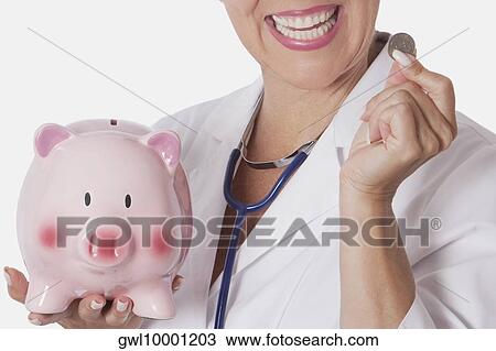 Female doctor holding a coin and a piggy bank View Large Photo Image Stock Image - Female doctor holding a coin and a piggy bank. Fotosearch