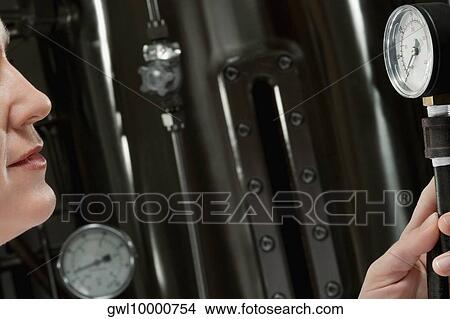 Picture - Female doctor holding a pressure gauge in a laboratory. Fotosearch