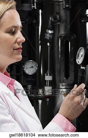 Picture - Female doctor holding a pressure gauge in a laboratory. Fotosearch